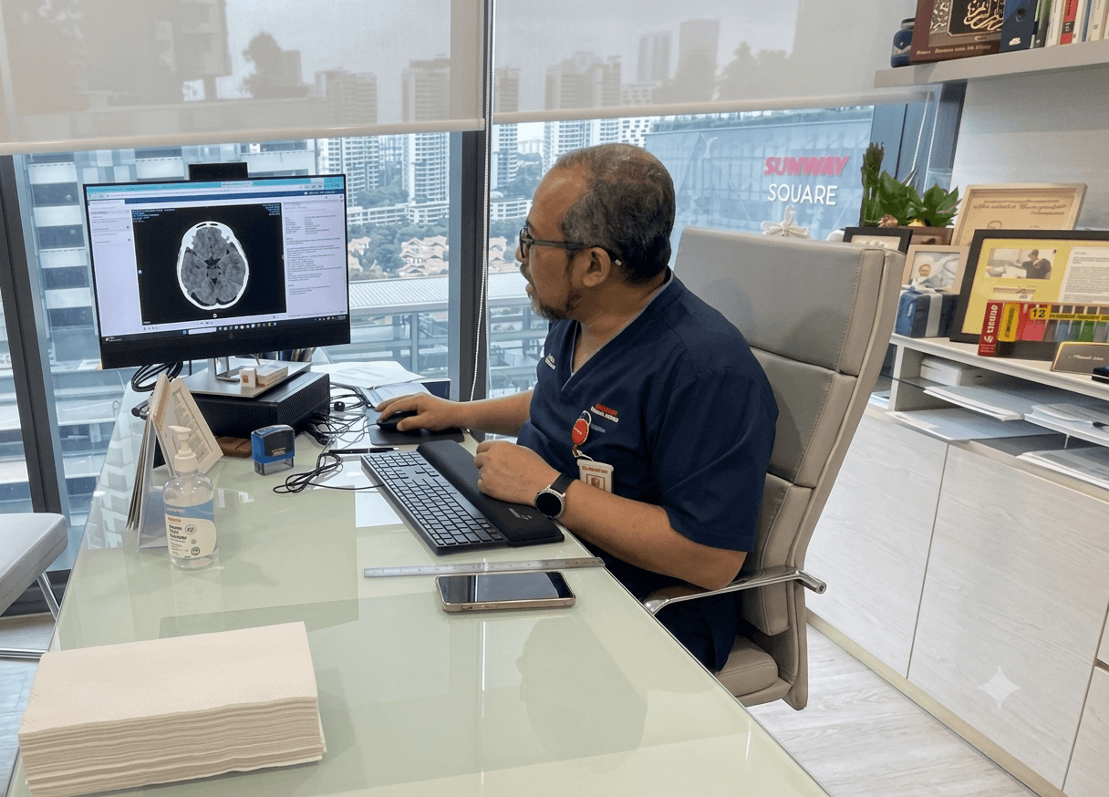 Dr Syed Abdullah Al-Haddad reviewing a scan with a patient